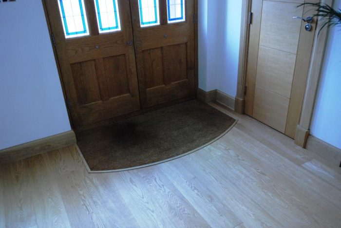 Inset foot mat set within oak flooring