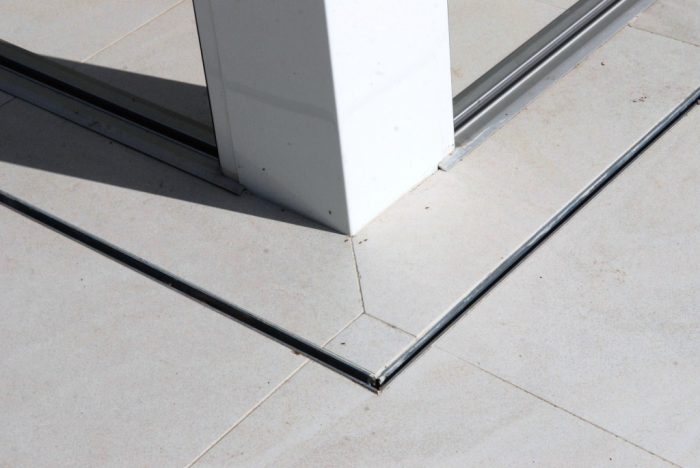 Minimalist post system and slot drain.  Note tiles run inside to out maintaining grout lines
